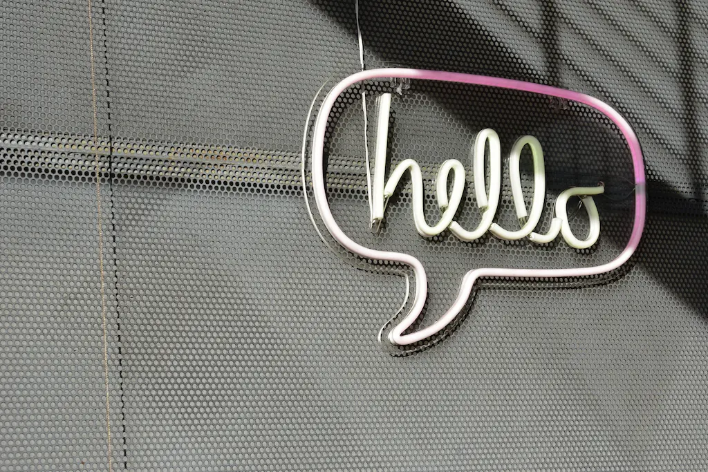 Neon sign shaped like a cartoon bubble that says hello.